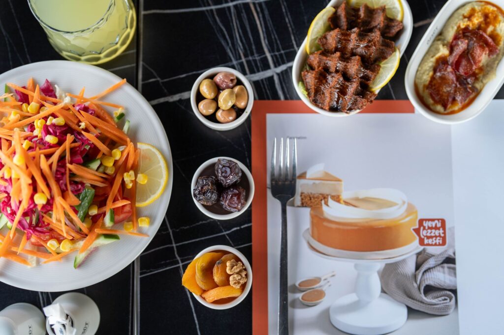 Vue de dessus d'un repas turc vibrant avec salades, apéritifs et dessert sur une table.