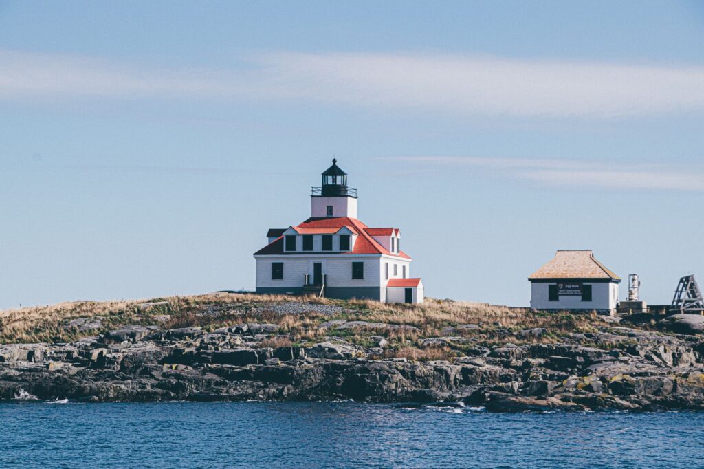 Charmant phare sur une côte rocheuse, idéal pour des projets de voyage ou sur le thème de l'océan.
