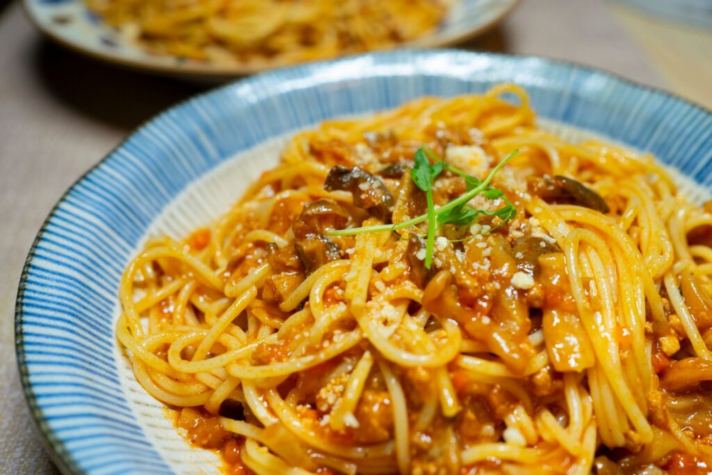 Gros plan d'un délicieux plat de spaghettis à la sauce tomate avec champignons et herbes, servi à Tokyo.