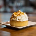 Une délicieuse tarte au citron meringuée sur une assiette carrée, parfaite pour les amateurs de desserts.
