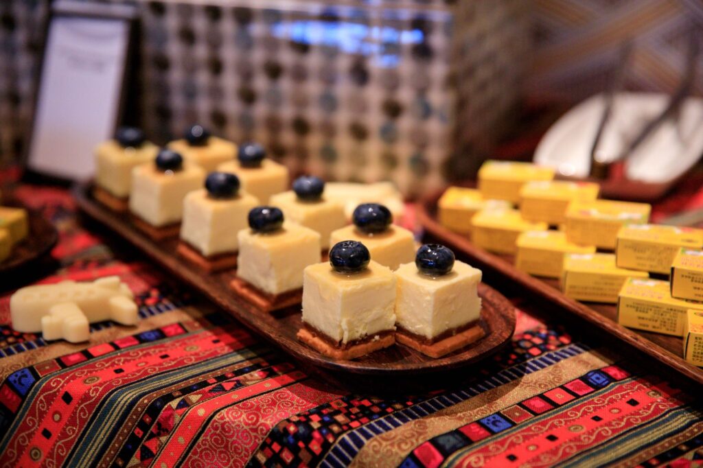 Gâteau au fromage aux myrtilles tranché servi sur une table à motifs colorés, parfait pour les amateurs de desserts.