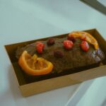 Un délicieux pain au chocolat garni de tranches d'agrumes et de baies, parfait pour le dessert.