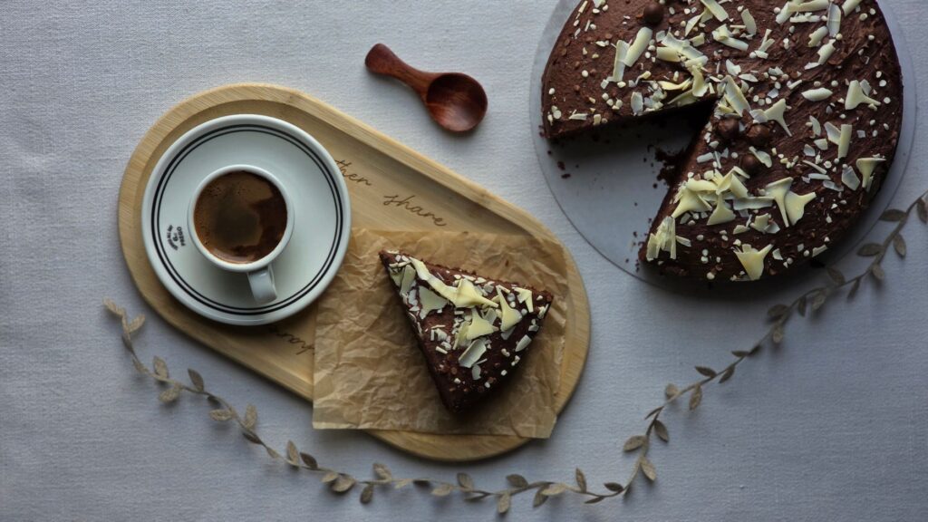 Délicieux gâteau au chocolat avec des copeaux de chocolat blanc et du café, parfait pour les moments cosy.
