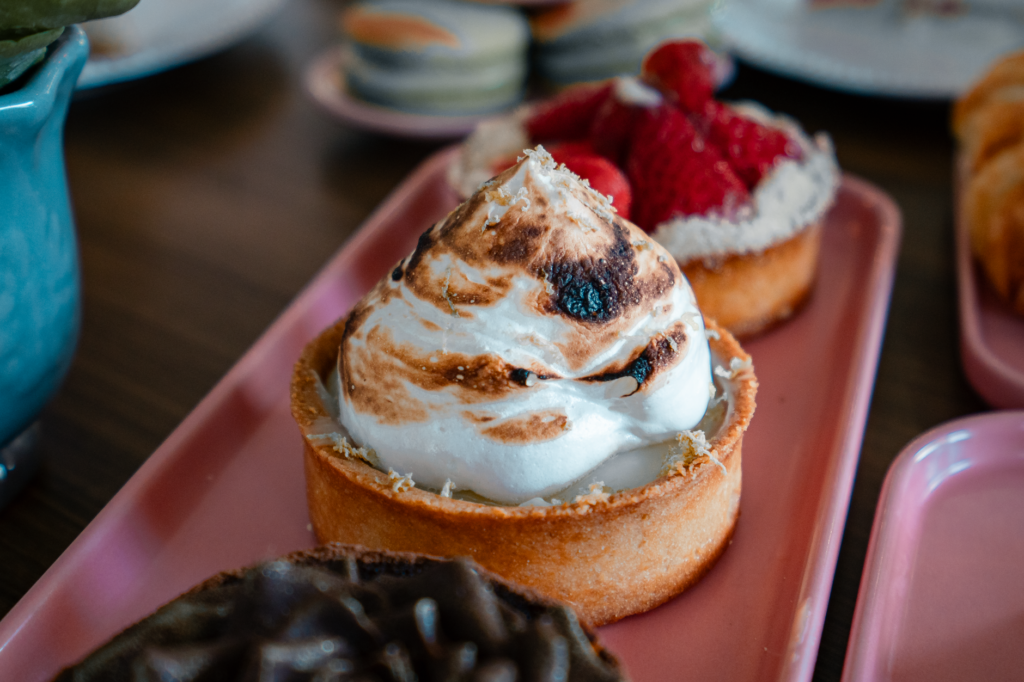 Gros plan de pâtisseries assorties sur des plateaux roses, parfaites pour le brunch ou le dessert.