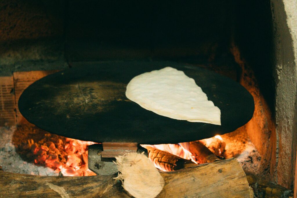 Pain plat turc authentique cuit sur un four à bois, illustrant les méthodes de cuisson traditionnelles.