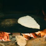 Pain plat turc authentique cuit sur un four à bois, illustrant les méthodes de cuisson traditionnelles.