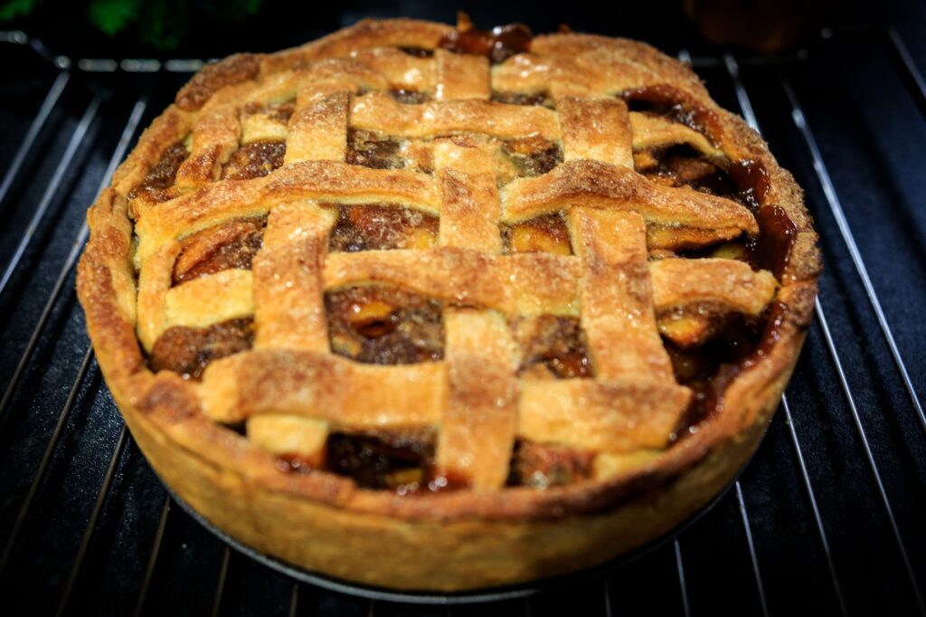 Savourez une tarte aux pommes maison parfaitement cuite avec une croûte en croisillons dorés.