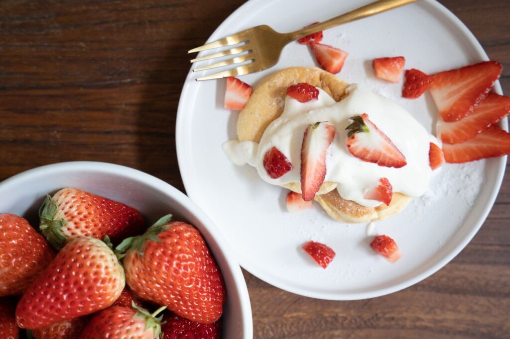 Vue de dessus d'un gâteau éponge aux fraises avec de la crème fouettée, parfait pour les amateurs de nourriture.