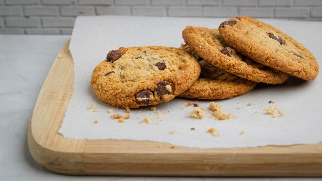 Délicieux biscuits maison aux pépites de chocolat sur papier sulfurisé, parfaits pour une petite douceur.