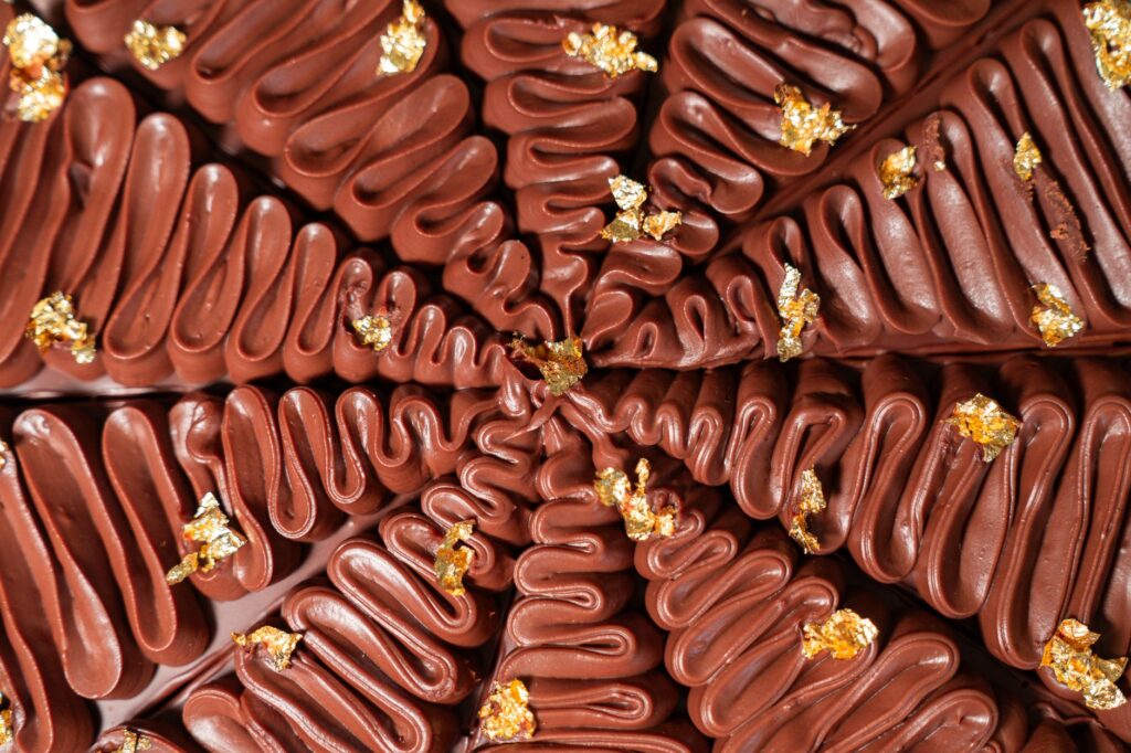 Gâteau au ganache au chocolat décadent orné d'accents de feuille d'or, un dessert parfait pour la haute cuisine.