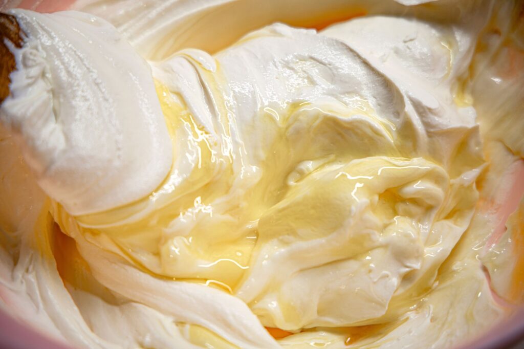 Gros plan sur une glace à la vanille onctueuse arrosée d'un filet de miel.