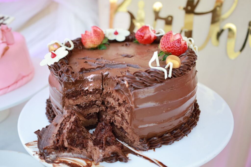 Un délicieux gâteau au chocolat garni de fraises et d'un glaçage décoratif, parfait pour les fêtes.