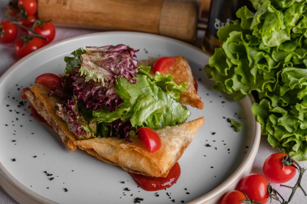 Un délicieux plat de pâtisserie garni de salade, de tomates cerises et de laitue fraîche.