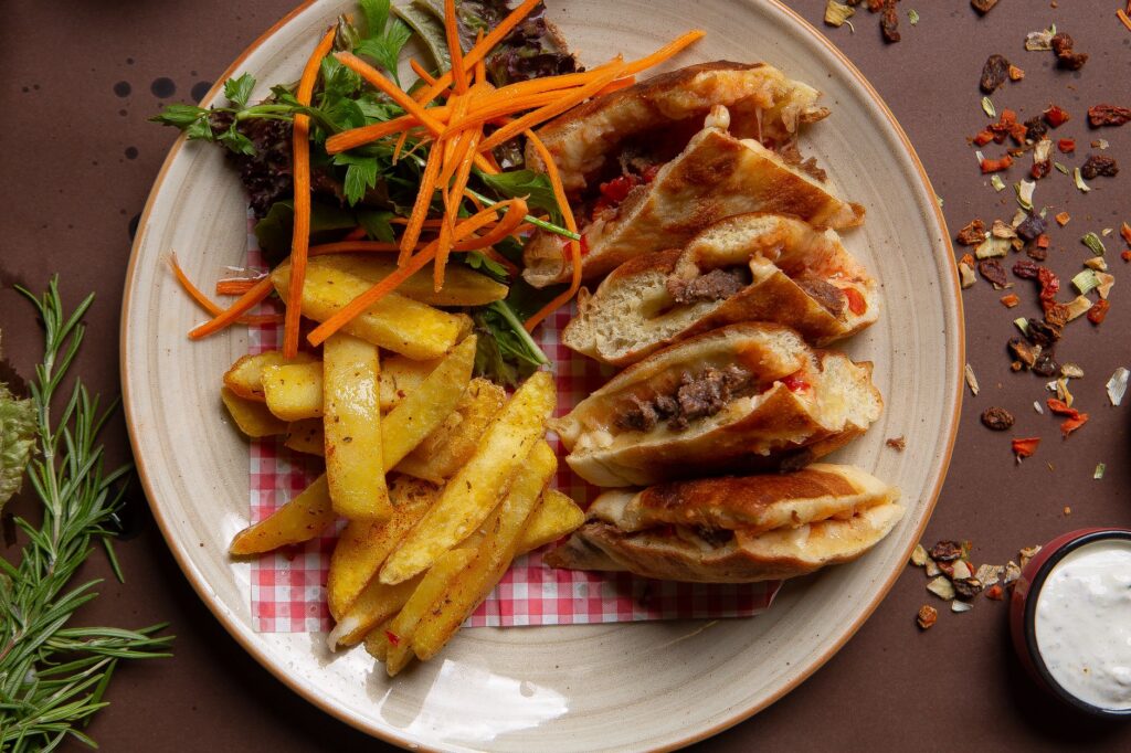 Une assiette de wraps au bœuf accompagnés de frites croustillantes et de salade fraîche, parfaite pour un repas savoureux.