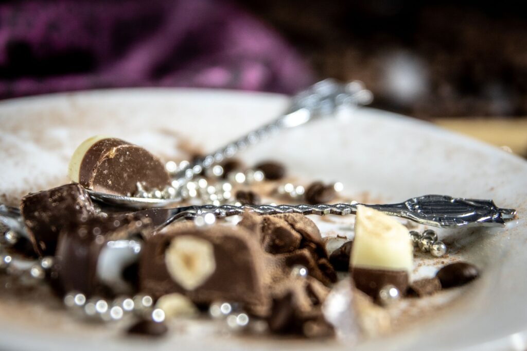 Gros plan décadent de chocolats assortis sur une assiette avec des couverts élégants.