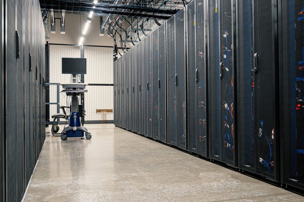 Couloir moderne d'un centre de données avec des racks de serveurs et du matériel informatique. Idéal pour des concepts de technologie et d'informatique.