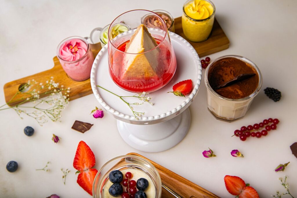 Délicieuse variété de desserts avec cheesecake et baies colorées sur un piédestal blanc.