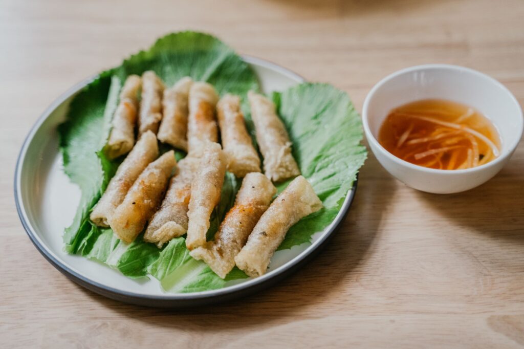 Délicieux rouleaux de printemps vietnamiens servis sur de la laitue avec une sauce trempette acidulée.
