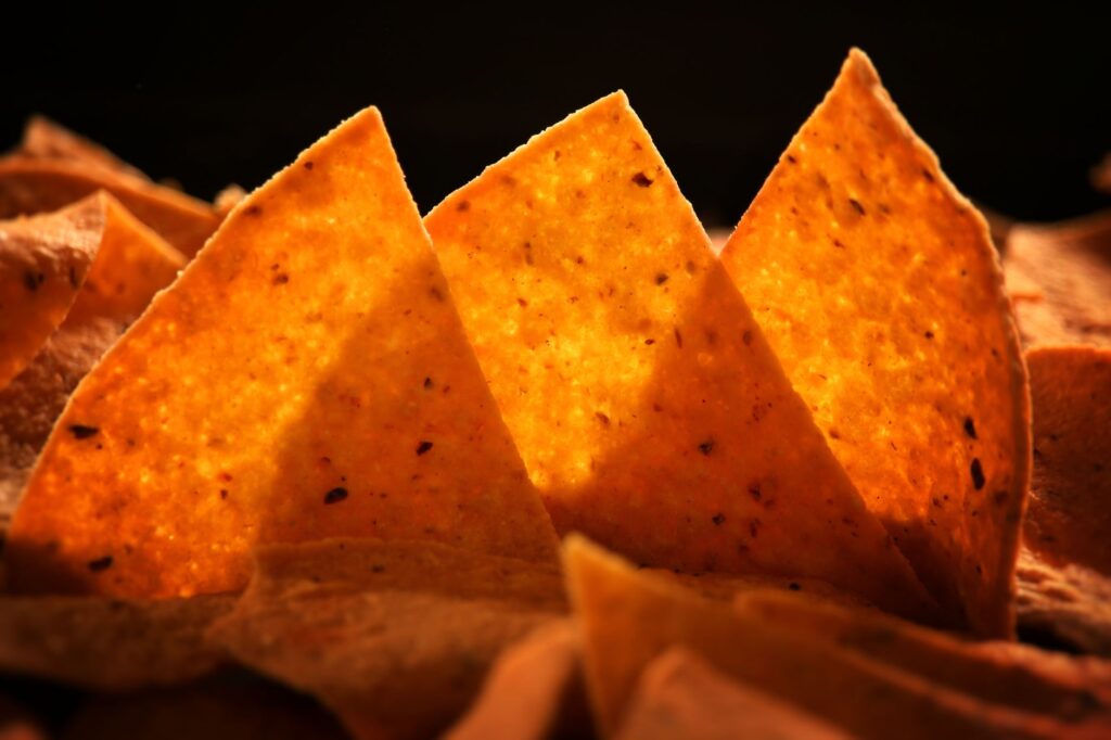 Délicieuses chips de maïs croustillantes parfaitement éclairées, mettant en valeur leur texture dorée et leur attrait invitant.