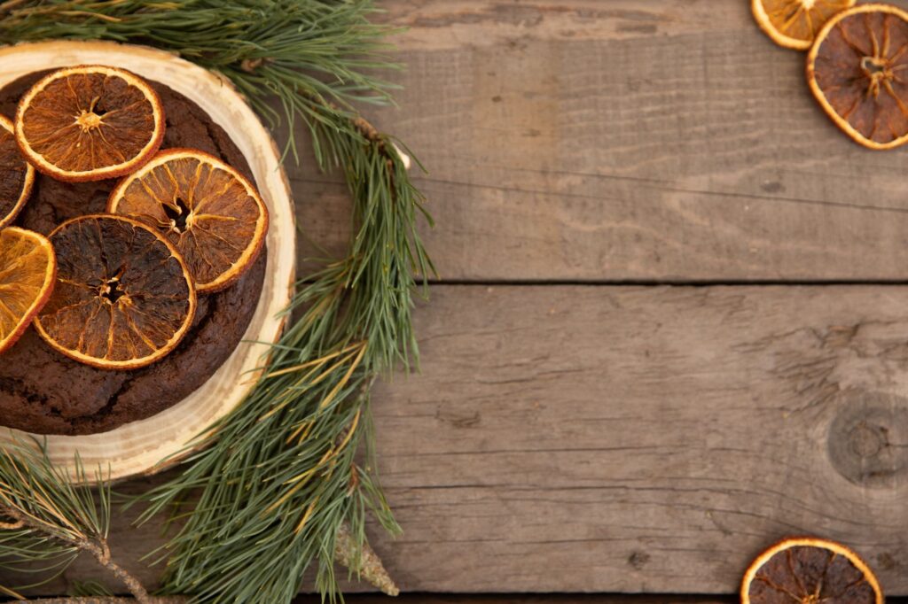 Un gâteau au chocolat orné d'oranges séchées, parfait pour un décor de dessert d'hiver rustique.