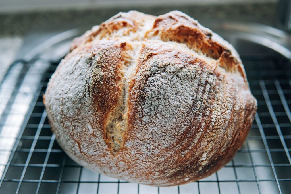 Pain artisanal fait maison avec une croûte dorée, refroidissant sur une grille.