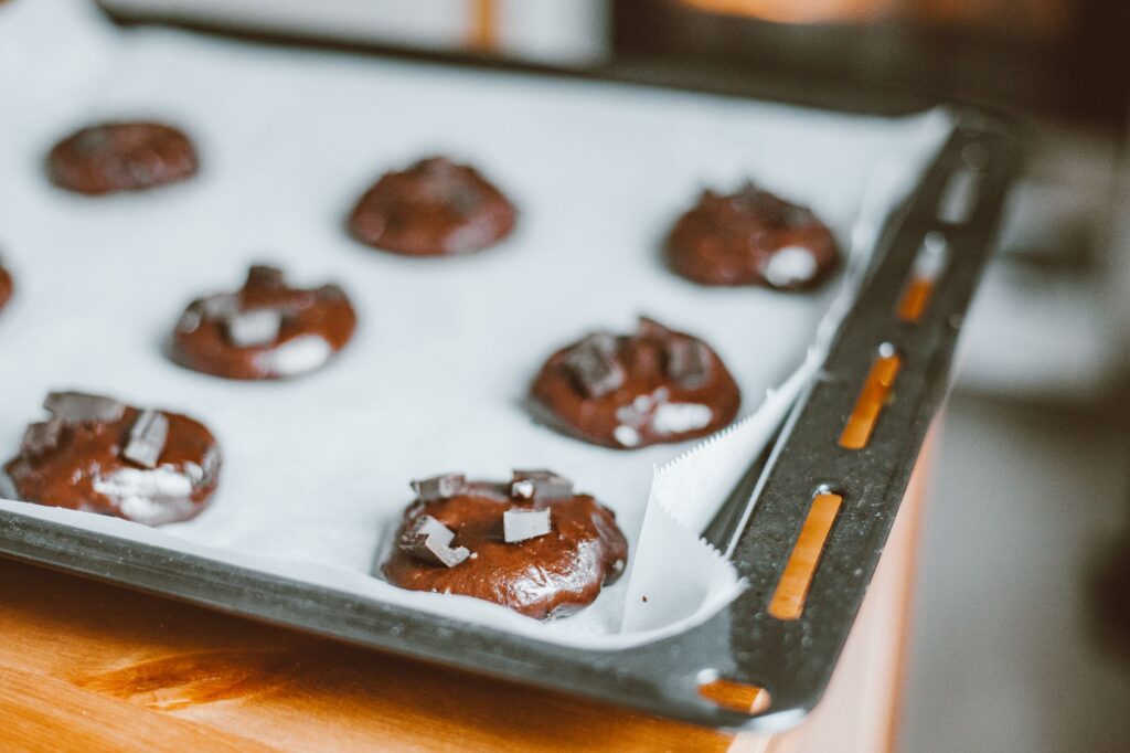 Des cookies aux pépites de chocolat fraîchement cuits refroidissent sur une plaque de cuisson. Parfait pour les amateurs de dessert.