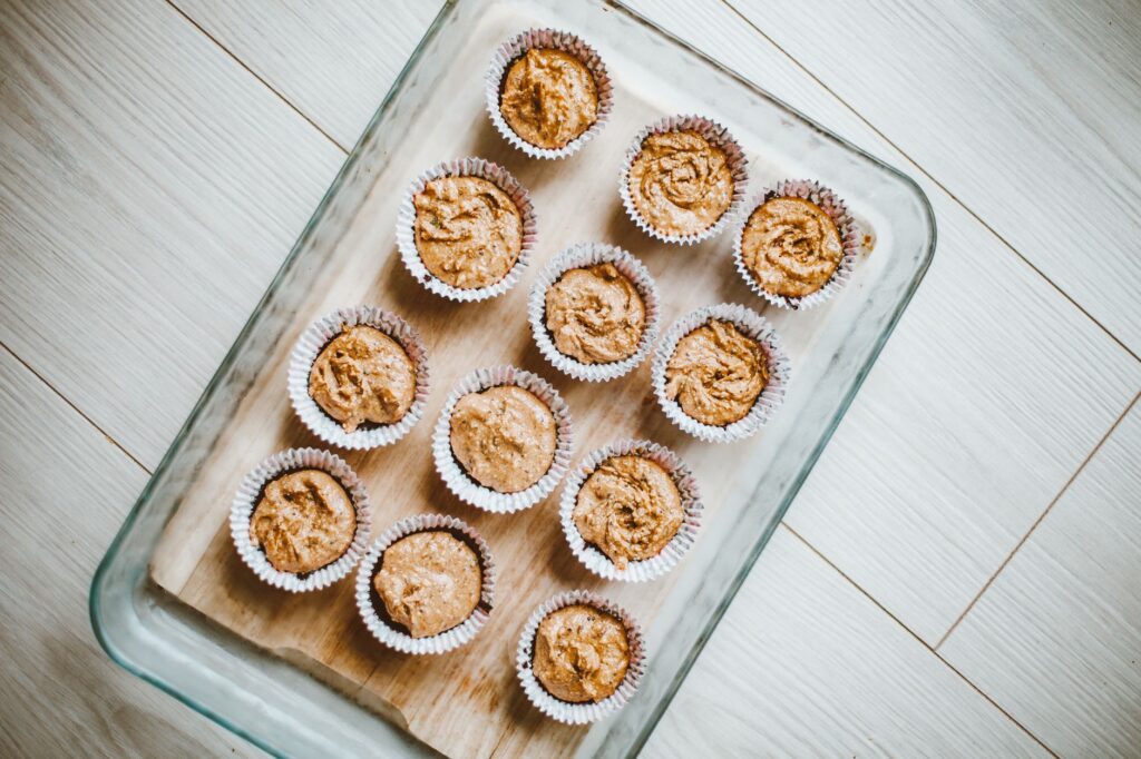 Des muffins fraîchement cuits dans un plat en verre vus d'en haut sur une surface en bois.