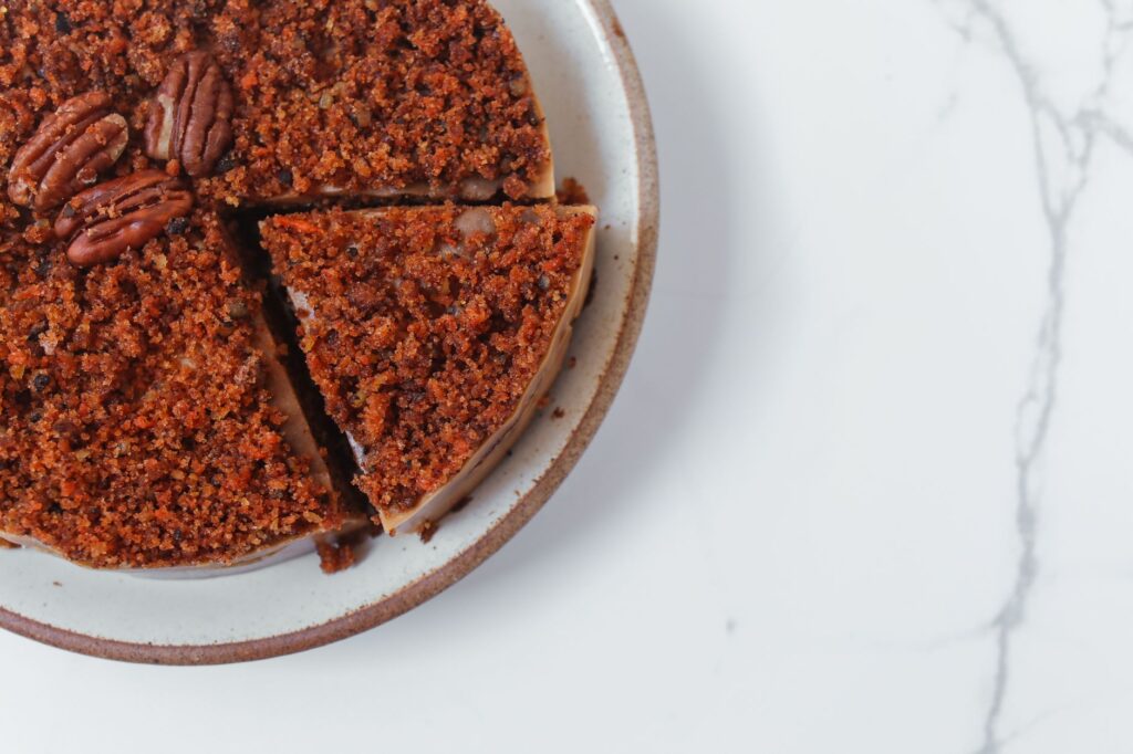 Vue de dessus d'une tarte aux noix de pécan en tranches sur une assiette en céramique.
