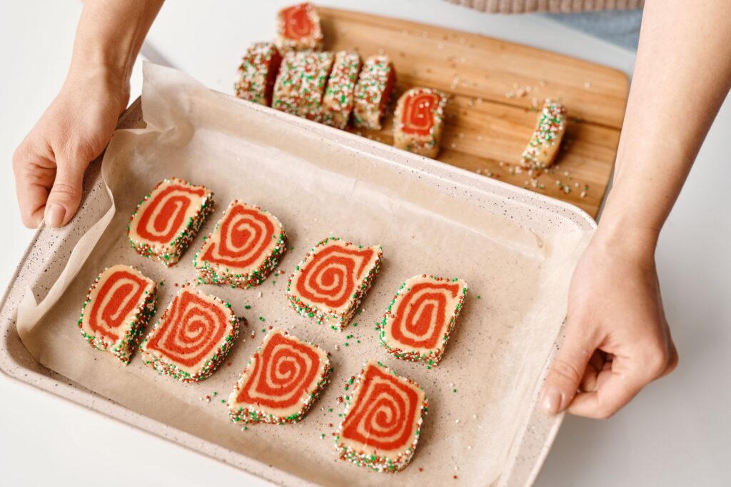 Biscuits spirales colorés avec des vermicelles sur un plateau de cuisson, parfaits pour les occasions festives.