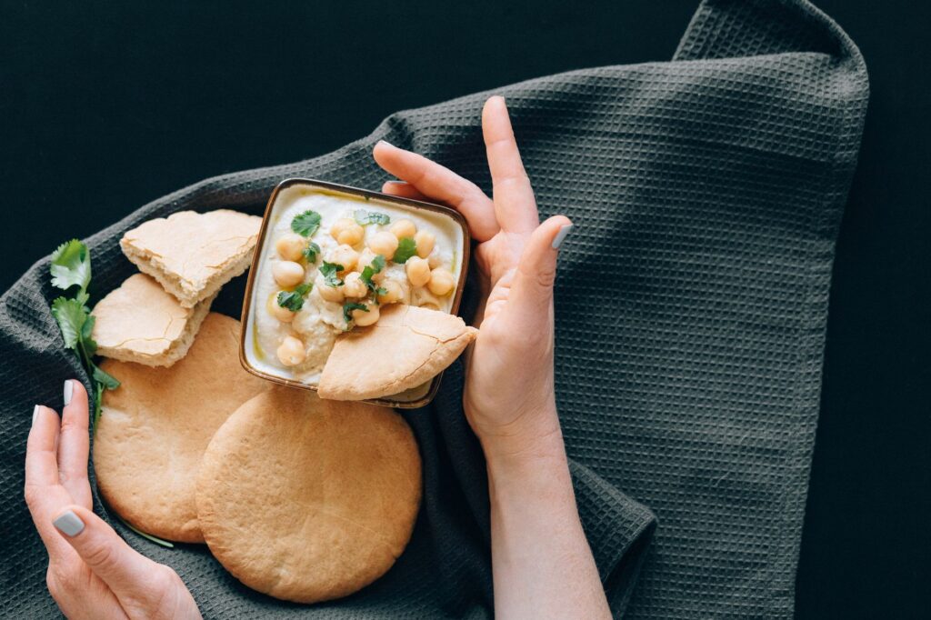 Délicieux houmous avec pois chiches servi avec du pain pita fraîchement cuit. Une entrée saine de la cuisine du Moyen-Orient.