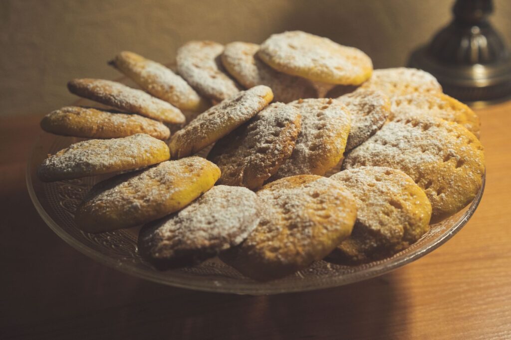 Une assiette de biscuits maison fraîchement cuits, saupoudrés de sucre glace, parfaits pour les friandises de fête.