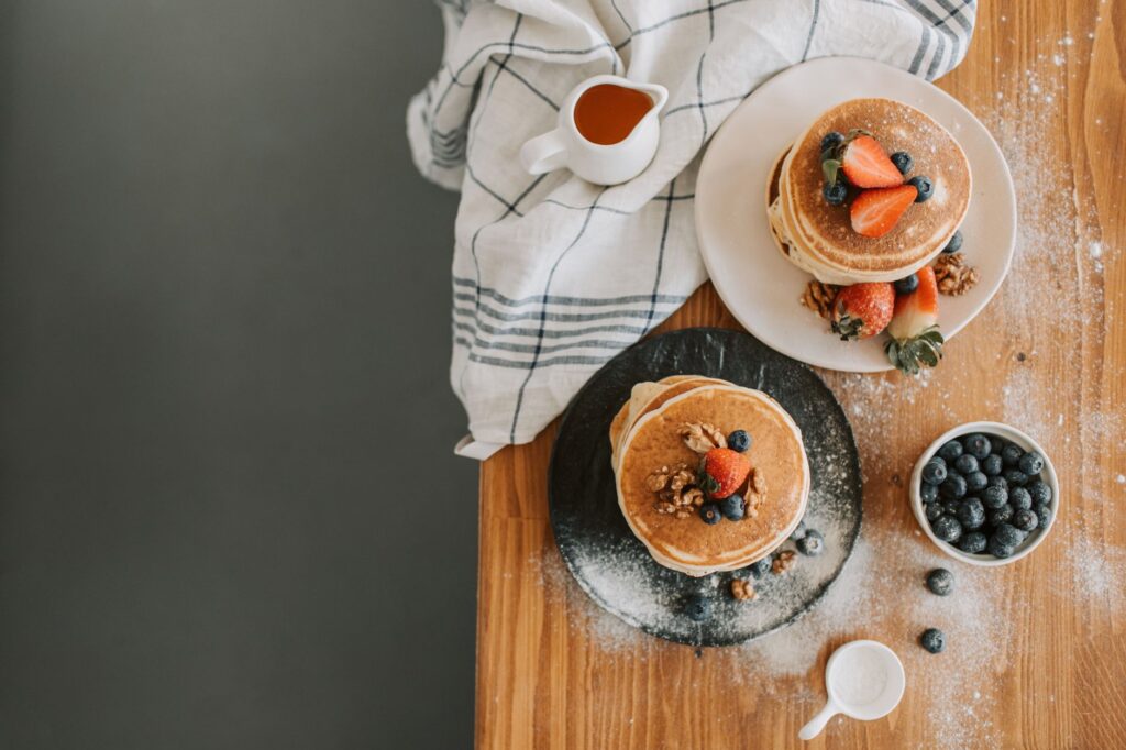 Vue aérienne de pancakes garnis de baies et de noix, parfaits pour l'inspiration du petit-déjeuner.