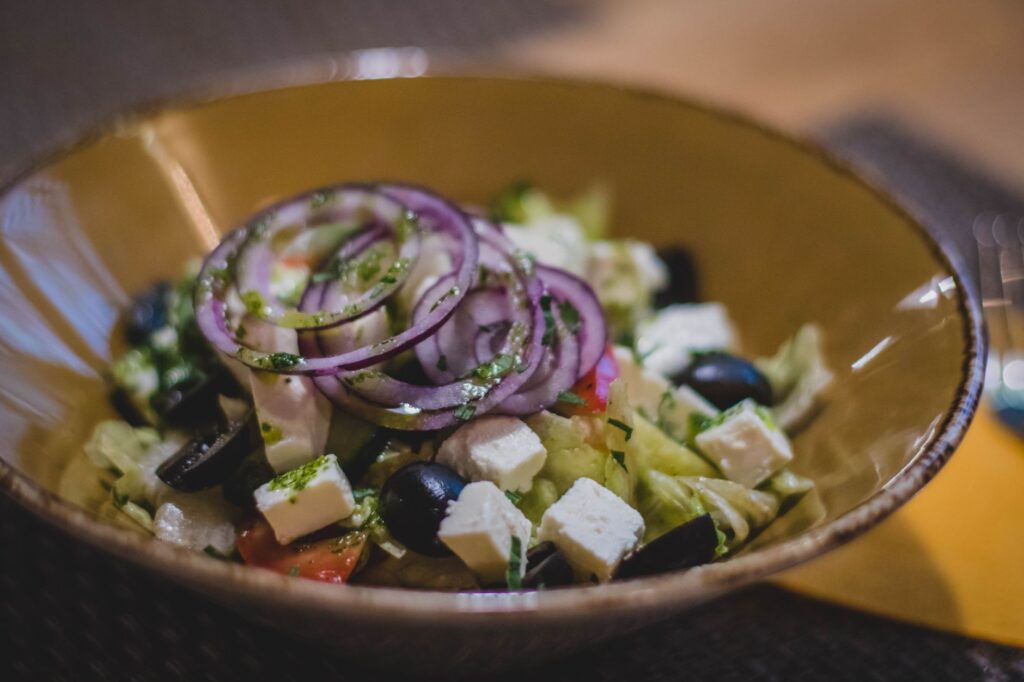 Une salade grecque délicieuse avec de la feta fraîche, des olives noires et des anneaux d'oignon rouge.