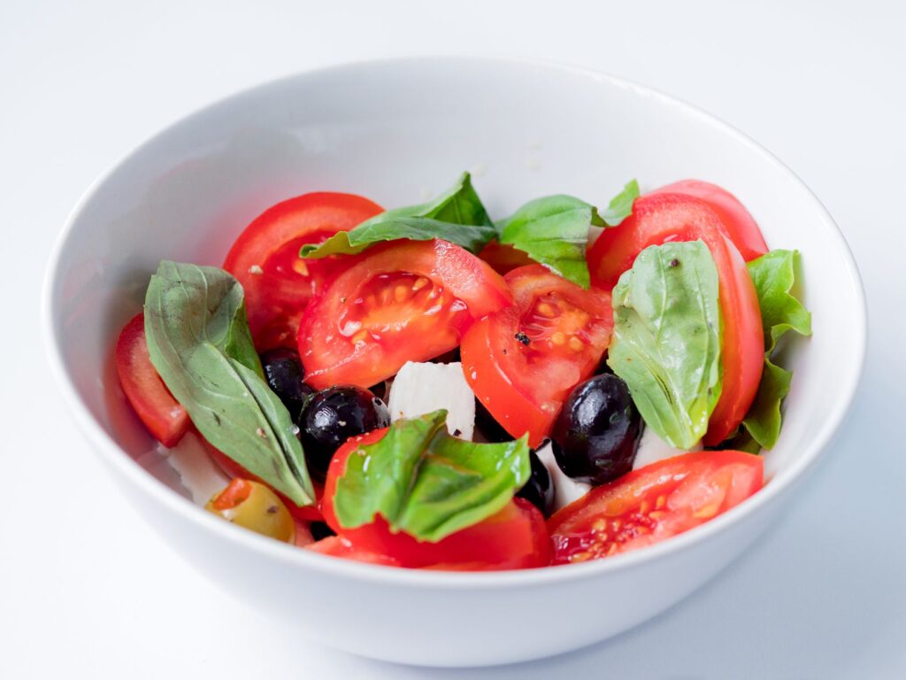 Délicieuse et colorée, cette salade caprese met en avant des ingrédients frais comme des tomates, du basilic et des olives.