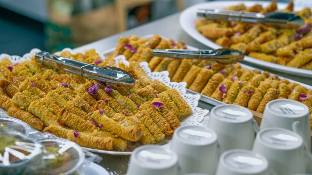 Une délicieuse variété de baklava traditionnel avec des pinces en exposition, parfaite pour les amateurs de cuisine.