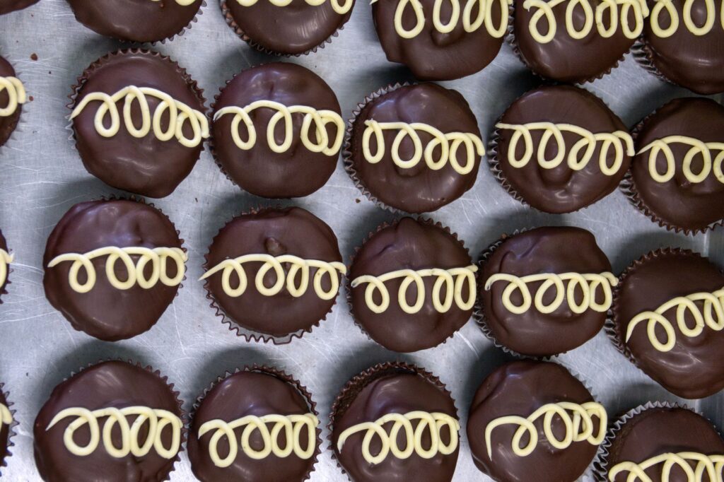 Vue de dessus de cupcakes au chocolat avec tourbillon de crème décorative sur un plateau, parfaits pour les amateurs de desserts.