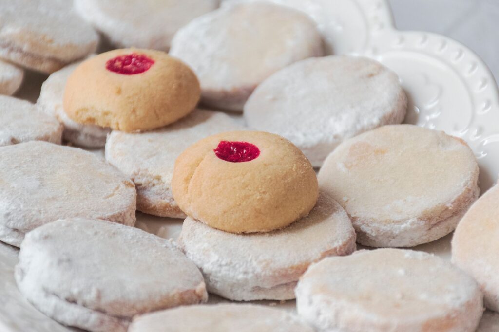 Gros plan de délicieux biscuits en sucre glace avec un nappage de cerise, idéal pour les amateurs de desserts.