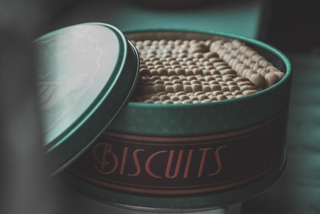 Une boîte en fer remplie de biscuits, créant une ambiance vintage et chaleureuse.