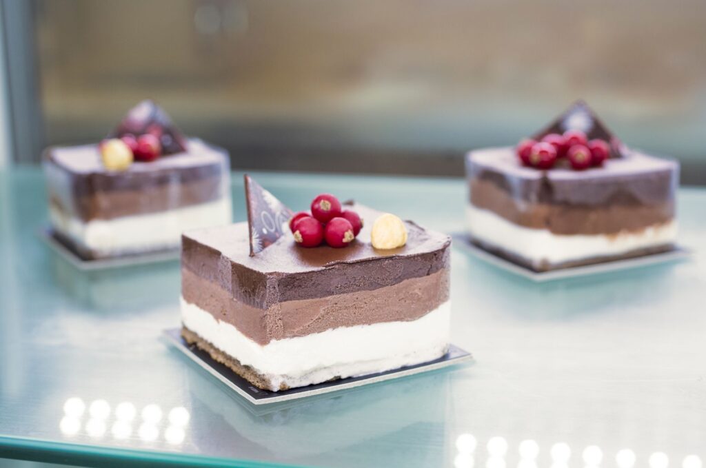 Délicieux gâteaux au chocolat mousse avec des baies et des noix sur une surface en verre.
