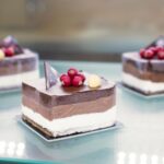 Délicieux gâteaux au chocolat mousse avec des baies et des noix sur une surface en verre.